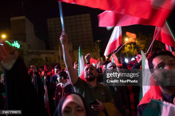 Iranians are waving Iranian flags as they celebrate Iran's IRGC UAV and missile attack against Israel in downtown Tehran, Iran, on April 14, 2024....