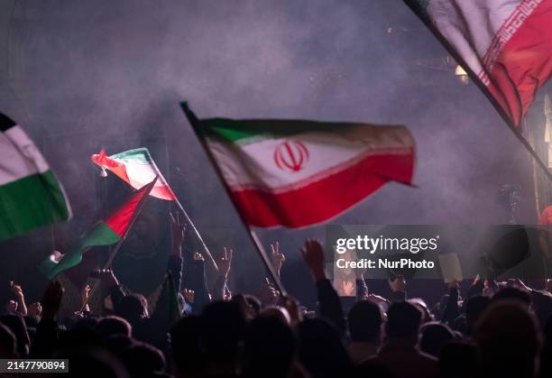Iranians are waving Iranian flags and a Palestinian flag while one of them is holding a portrait of Qassem Soleimani, the former commander of the...