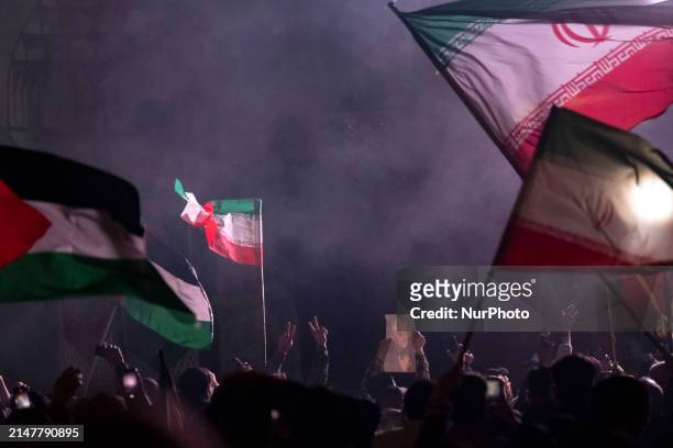 Iranians are waving Iranian flags and a Palestinian flag while one of them is holding a portrait of Qassem Soleimani, the former commander of the...