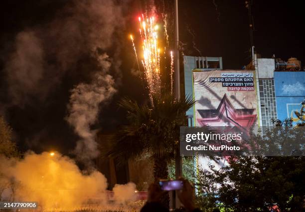 Fireworks are going off next to an anti-Israeli mural during a celebration in support of Iran's IRGC UAV and missile attack against Israel, in...