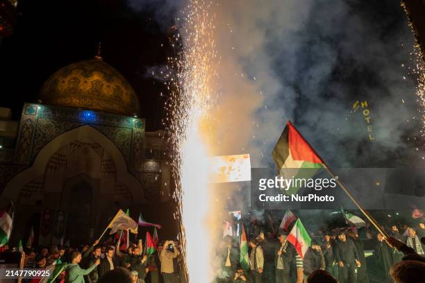 Iranians are waving an Iranian flag and a Palestinian flag as they celebrate Iran's IRGC UAV and missile attack against Israel in downtown Tehran,...