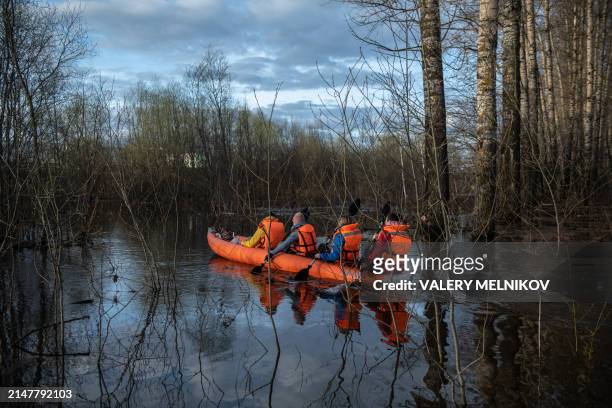 People travel in a boat in floodwater from the overflowing Nerl River outside the settlement of Bogolyubovo in the Vladimir region on April 13, 2024.