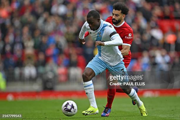 Crystal Palace's English defender Tyrick Mitchell vies with Liverpool's Egyptian striker Mohamed Salah during the English Premier League football...