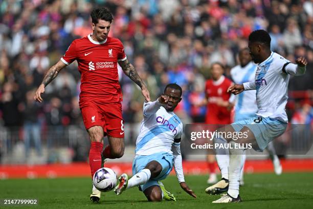 Liverpool's Hungarian midfielder Dominik Szoboszlai is tackled by Crystal Palace's English defender Tyrick Mitchell during the English Premier League...