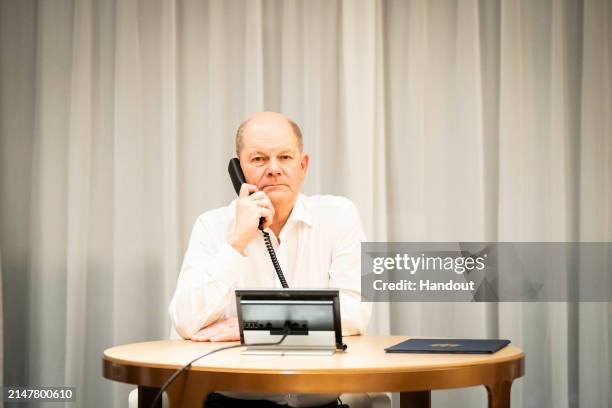 In this handout image provided by German Government Press Office and distributed via dpa, German Chancellor Olaf Scholz takes part in a phone call...