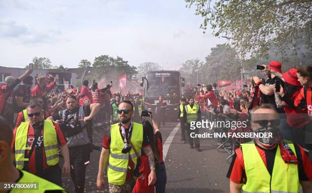 Fans of Bayer Leverkusen celebrate as the bus carrying the players arrives ahead the German first division Bundesliga football match Bayer 04...