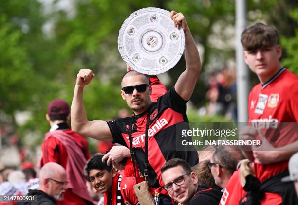 Fan of Bayer Leverkusen celebrates with a mock Bundesliga trophy ahead the German first division Bundesliga football match Bayer 04 Leverkusen v...