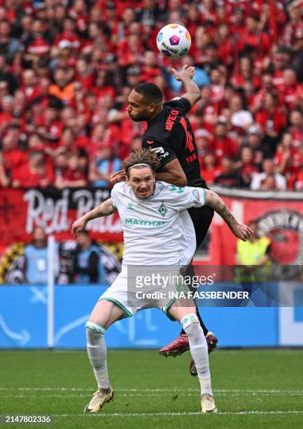 Bayer Leverkusen's German defender Jonathan Tah jumps to head the ball next to Bremen's German forward Nick Woltemade during the German first...