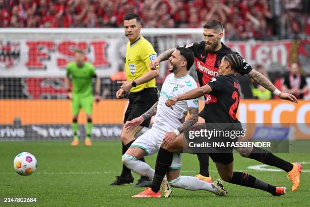 Bremen's German midfielder Leonardo Bittencourt is tackled by Bayer Leverkusen's French forward Amine Adli next to Bayer Leverkusen's German...