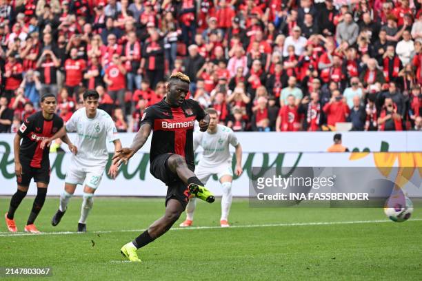 Bayer Leverkusen's Nigerian forward Victor Boniface scores the opening goal from the penaty spot during the German first division Bundesliga football...