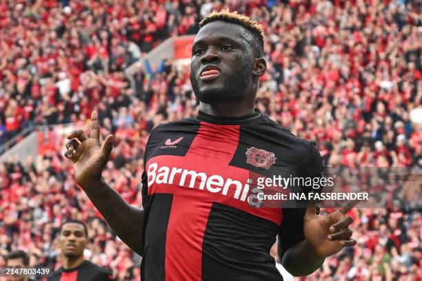 Bayer Leverkusen's Nigerian forward Victor Boniface celebrates scoring the opening goal from the penaty spot with his teammates during the German...