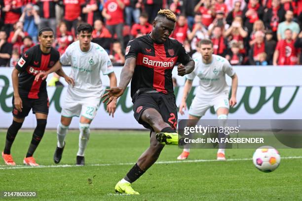 Bayer Leverkusen's Nigerian forward Victor Boniface scores the opening goal from the penaty spot during the German first division Bundesliga football...