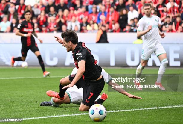 Bayer Leverkusen's German midfielder Jonas Hofmann is fouled by Bremen's Argentinia defender Julian Malatini giving away a penalty during the German...