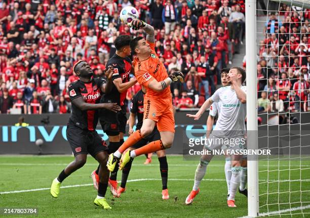 Bayer Leverkusen's Ecuadorian defender Piero Hincapie gets up to head the ball next to Bremen's German goalkeeper Michael Zetterer and Bayer...