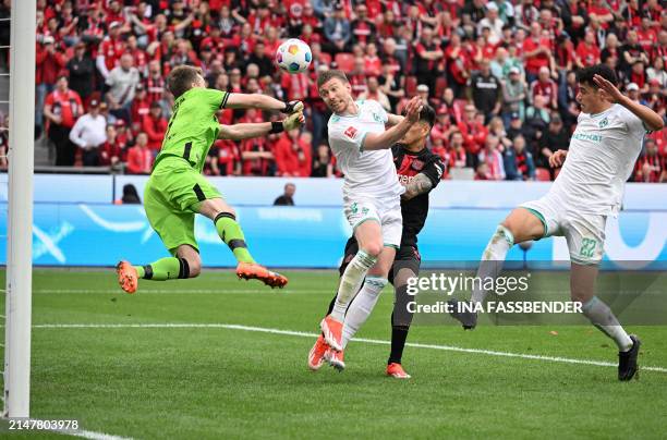 Bremen's Argentinia defender Julian Malatini attempts to score a header past Bayer Leverkusen's Finnish goalkeeper Lukas Hradecky during the German...