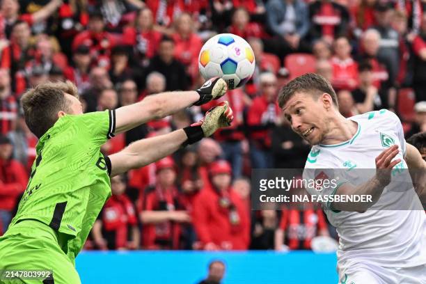 Bremen's Argentinia defender Julian Malatini attempts to score a header past Bayer Leverkusen's Finnish goalkeeper Lukas Hradecky during the German...