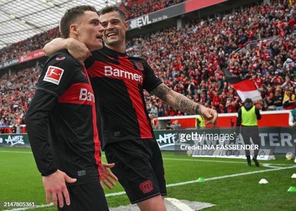 Bayer Leverkusen's German midfielder Florian Wirtz celebrates scoring the 3-0 goal with his team-mate Bayer Leverkusen's Swiss midfielder Granit...