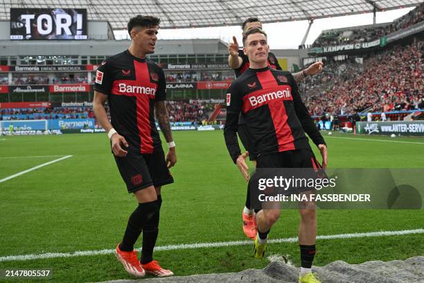 Bayer Leverkusen's German midfielder Florian Wirtz celebrates scoring the 3-0 goal with his team-mate Bayer Leverkusen's Ecuadorian defender Piero...