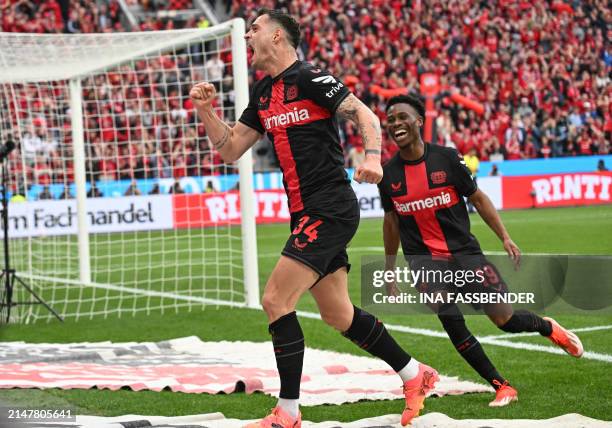 Bayer Leverkusen's Swiss midfielder Granit Xhaka celebrates scoring the 2-0 goal with his team-mate Bayer Leverkusen's English midfielder Nathan...