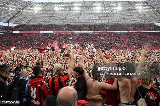 Leverkusen fans celebrate on the pitch after the German first division Bundesliga football match Bayer 04 Leverkusen v Werder Bremen in Leverkusen,...