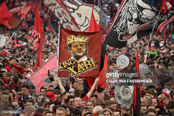 Leverkusen fans celebrate on the pitch with a banner of "King Xabi" after the German first division Bundesliga football match Bayer 04 Leverkusen v...