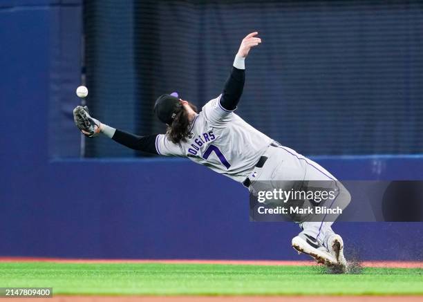 Brendan Rodgers of the Colorado Rockies can't catch a fly ball against the Toronto Blue Jays during the first inning in their MLB game at the Rogers...