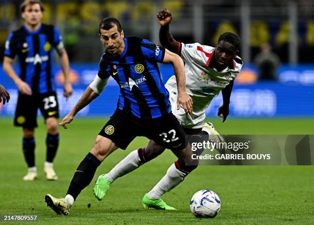 Inter Milan's Armenian midfielder Henrikh Mkhitaryan and Cagliari's Angolan forward Zito Luvumbo vie during the Italian Serie A football match...