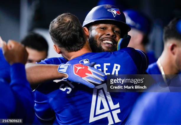 Vladimir Guerrero Jr. #27 of the Toronto Blue Jays celebrates scoring with George Springer against the Colorado Rockies during the third inning in...