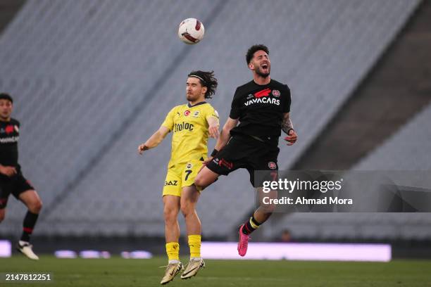 April 14: Ferdi Kadioglu of Fenerbahce jumps for the ball with Can Keles of Fatih Karagumruk during the Turkish Super League match between Fatih...