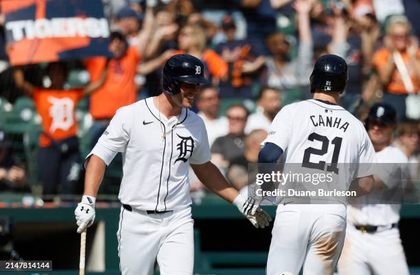 Mark Canha of the Detroit Tigers is congratulated by Kerry Carpenter after scoring to take a 4-3 lead over the Minnesota Twins at Comerica Park on...
