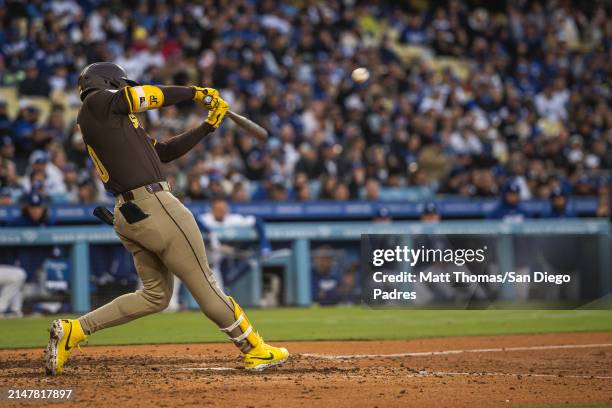 Jurickson Profar of the San Diego Padres hits a 3-run double in the seventh inning against the Los Angeles Dodgers at Dodger Stadium on April 14,...