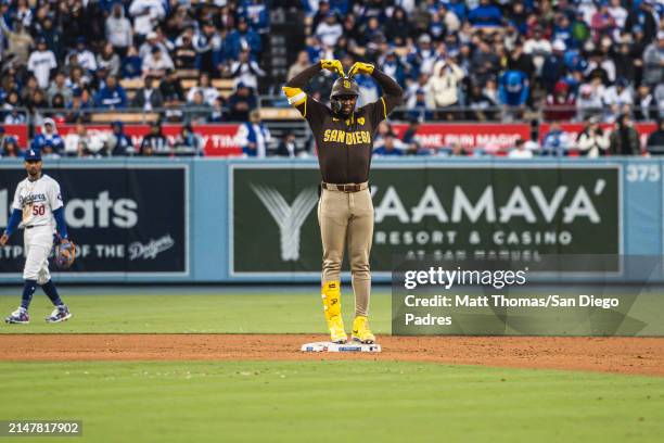 Jurickson Profar of the San Diego Padres celebrates after hitting a 3-run double in the seventh inning against the Los Angeles Dodgers at Dodger...