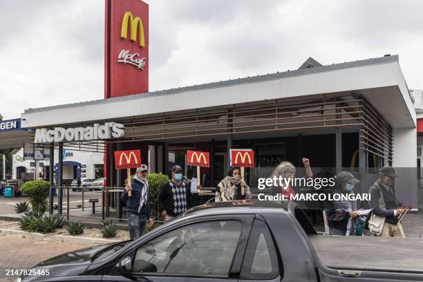 Demonstrators carry placards calling for the boycott of the fast food chain McDonald's, accused of allegedly giving free meals to the Israeli...