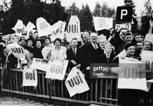 People supporting the new draft French constitution put by General de Gaulle to referendum hold up "Yes" signs on September 20, 1958 in Rennes during...