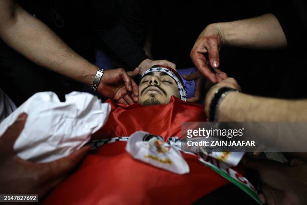 Relatives mourn over the body of Yazan Shtayeh, who was killed during clashes with Israeli forces in Nablus, during his funeral in the village of...