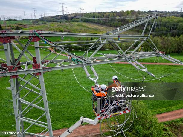 April 2024, Saxony, Limbach-Oberfrohna: Fitters renew a 110 KV high-voltage line of the electricity grid operator Mitnetz. The largest distribution...