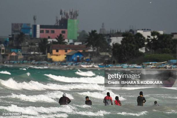 People enjoy along the shores in the Sri Lankan coast near Trincomalee on April 15, 2024.