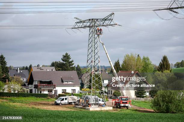 April 2024, Saxony, Limbach-Oberfrohna: Fitters renew a 110 KV high-voltage line of the electricity grid operator Mitnetz. The largest distribution...