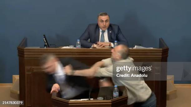 Screen grab captured from the video shows opposition MP Aleko Elisashvili punching the leader of the ruling Georgian Dream party, Mamuka Mdinaradze,...