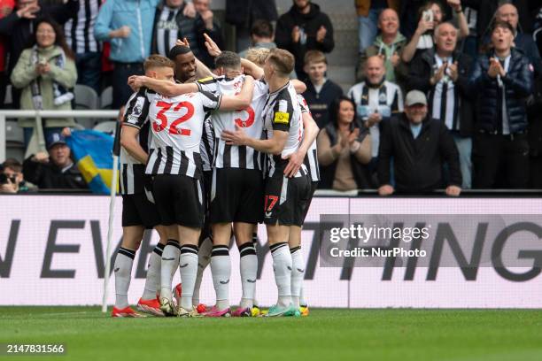 Newcastle United players are congratulating Alexander Isak after he scores his team's third goal during the Premier League match between Newcastle...