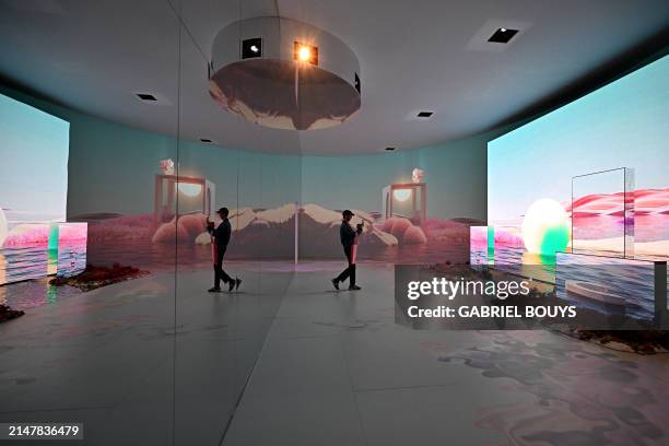 Visitor photographs the immersive design installation "Newfound Equilibrium" presented by Samsung, as part of the Fuorisalone 2024 event, on the eve...