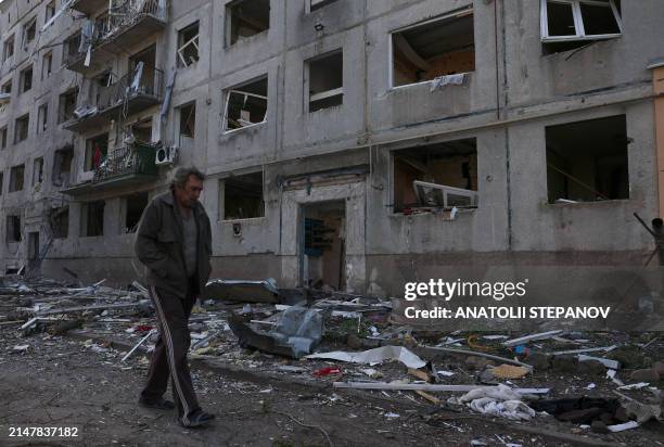 Man walks by houses which were destroyed by artillery fire and air raids in the village of Ocheretyne not far from Avdiivka town in the Donetsk...