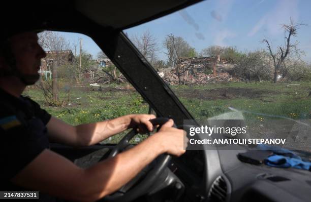 An officer rides past a house destroyed by artillery fire and air raids in the village of Ocheretyne not far from Avdiivka town in the Donetsk...