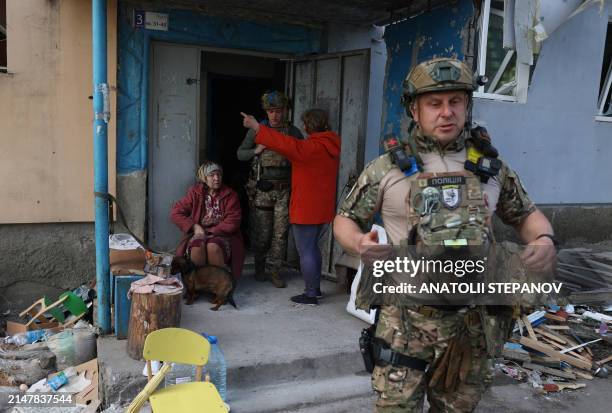 Officers of the special police force "White Angel" Hennadiy Yudin, 47 and Dmytro Solovyi, 23 talk with women during the evacuation of local residents...