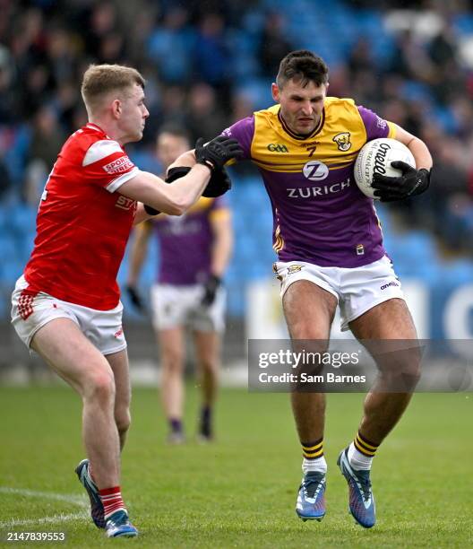 Laois , Ireland - 14 April 2024; Glen Malone of Wexford in action against Peter Lynch of Louth during the Leinster GAA Football Senior Championship...