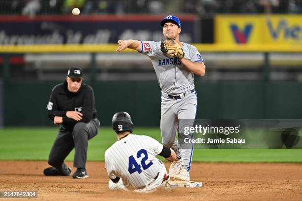 Adam Frazier of the Kansas City Royals forces out Andrew Benintendi of the Chicago White Sox and throws to first base to complete a double play in...