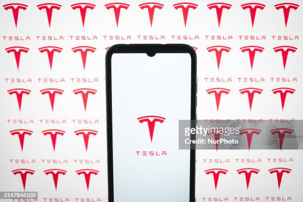 In this photo illustration, the Tesla logos are being displayed on a smartphone screen and on a computer screen in Athens, Greece, on April 16, 2024.