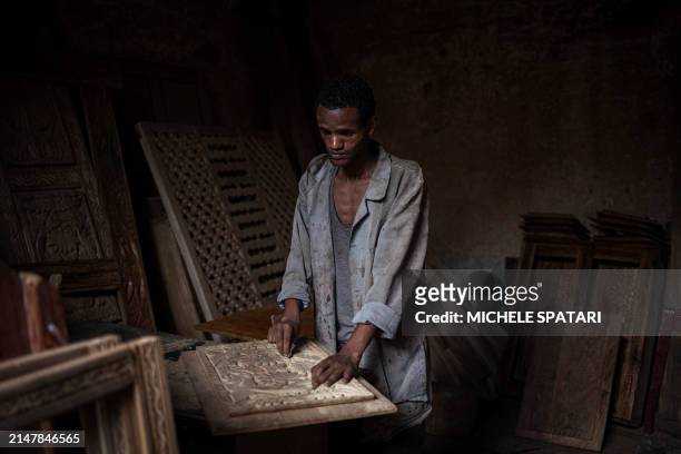 Carpenter engraves a piece of a traditional Harari door at his workshop in the walled city of Harar on April 15, 2024. Founded in the 10th century,...