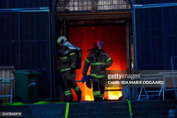 Firefighters work at the main entrance of the historic Boersen stock exchange building which is on fire in central Copenhagen, Denmark on April 16,...