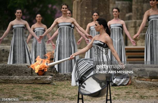 Greek actress Mary Mina, playing the role of the High Priestess, lights the torch during the flame lighting ceremony for the Paris 2024 Olympics...